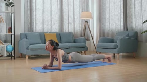 Young Adult Woman Planking on Yoga Mat Indoors