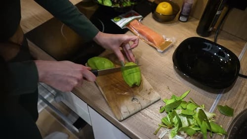Female Hands Cutting Avocado in Pieces