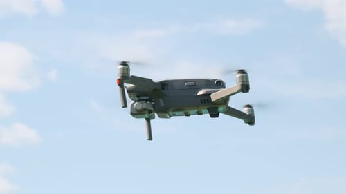 Gray Drone Hovering in a Blue Sky