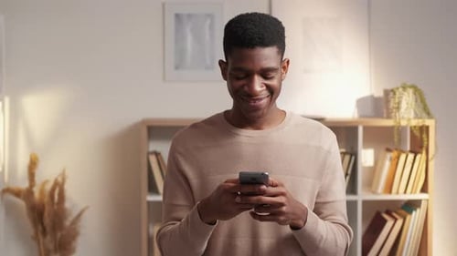 Smiling Man Using Smartphone Indoors