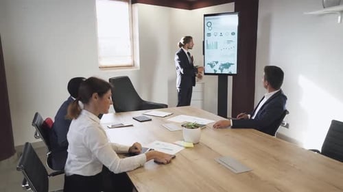 Business Meeting in Office Young Businessman Speak at a Meeting and Shows Financial Infographic in