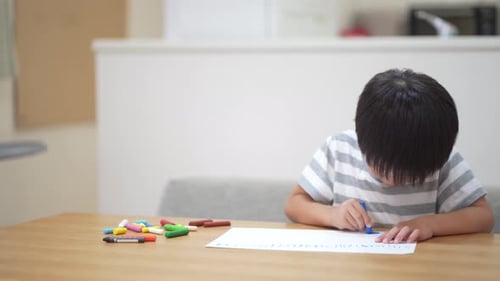 Focused Child Drawing with Crayons at Table