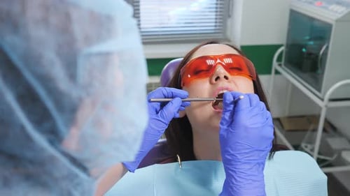 Junges Mädchen mit Schutzbrille bei Vorsorgeuntersuchung im Zahnarztstuhl der Zahnklinik
