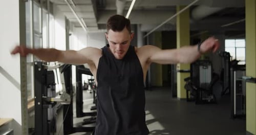 Young Muscular Athlete Works Out in a Modern Gym Making Warmup Exercises