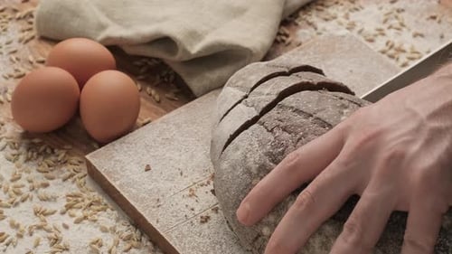 Slicing Bread on Wooden Cutting Board. Wholegrain Bread on Chopping Board.
