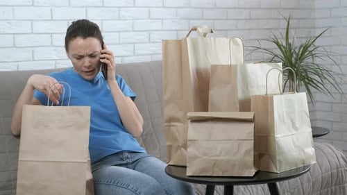 Woman Talking on Phone Sitting Near Paper Bags