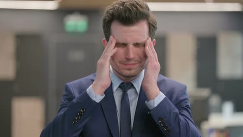 Stressed Man Rubbing Temples Experiencing Headache