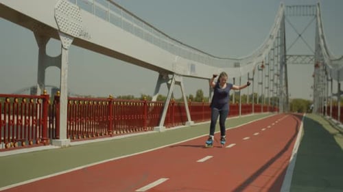 Woman Roller Skating on Bridge on Sunny Day