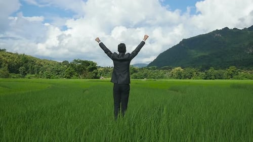 Man in Suit Reaches Field's Edge With Arms Raised