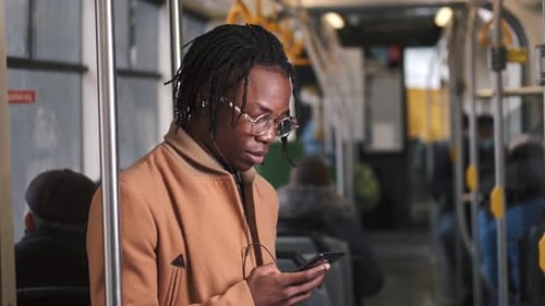 Young Adult Using Smartphone on Public Transportation