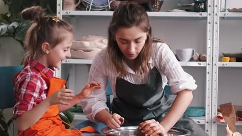 Woman and Child Shaping Clay in Pottery Studio