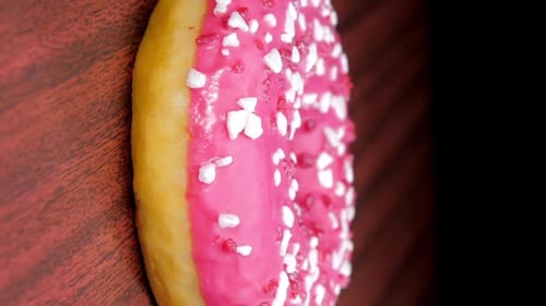 Delicious Donut Covered in Pink Frosting and Sprinkles