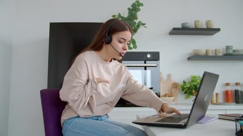 Mujer bonita con anomalía de nacimiento en auriculares que brinda atención al cliente en línea en interiores