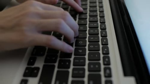 Woman's hands Typing on a Laptop Keyboard