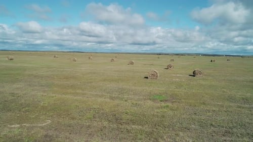 Vista aérea a baja altitud de una pradera verde con pacas de heno