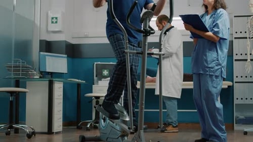 Man Uses Elliptical with Medical Staff Observing