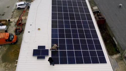 Installing Solar Panels on Urban Rooftop, Aerial View