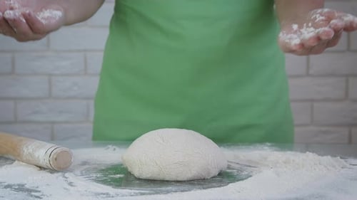 Klatschen Sie die Hände einer Frau auf Mehl