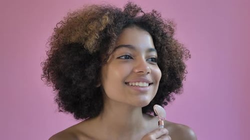 Young Woman Uses Facial Roller for Beauty Treatment