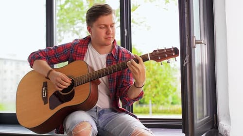 Man Plays Guitar by Window