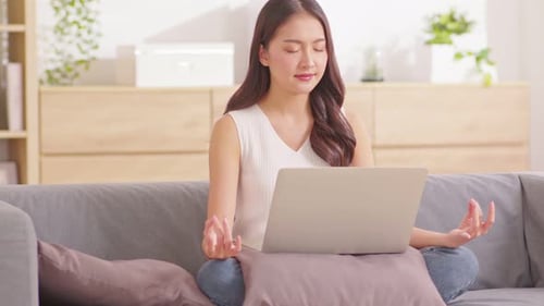 Woman Meditating with Laptop on Lap at Home