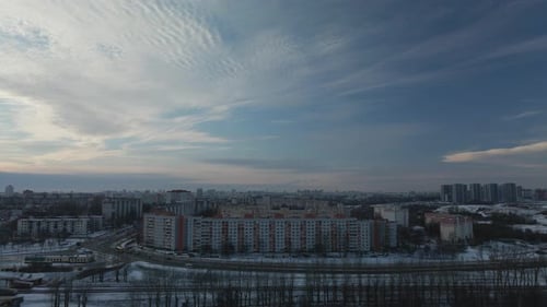 Flying in a suburban park. City blocks are visible. Winter cityscape.