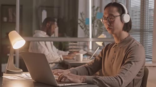 Asian Programmer Working in Office at Night
