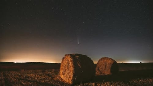 Comet Neowise C2020F3 In Night Starry Sky Above Haystacks In Summer Agricultural Field. Stars Above