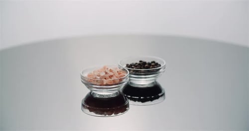 Pepper and Himalayan Salt in Bowl Rotating on Table
