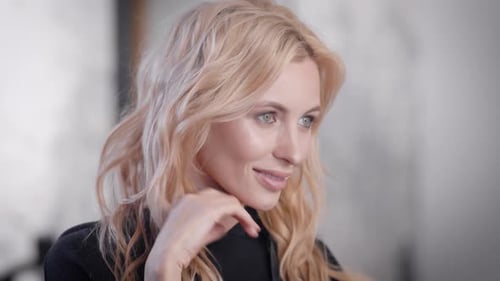 Elegant Woman with Blonde Wavy Hair Indoors