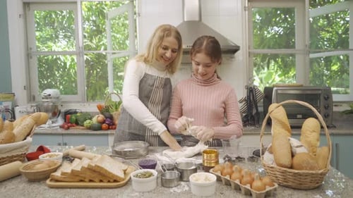 Woman and Teen Baking Bread Together in Kitchen