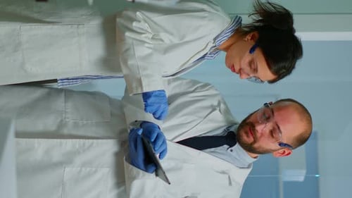 Scientists Review Data on Tablet in Laboratory