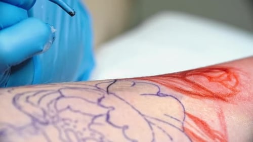Tattoo Artist Working with Electric Needle and Blue Ink