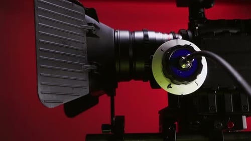 Professional Video Camera with Lens on Red Backdrop