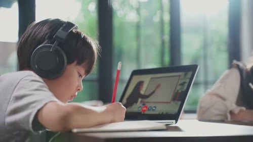 Homeschool Asian little young girl learn online class from school teacher by digital remote internet