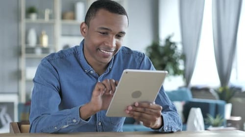 Adult Using Tablet at Home Smiling