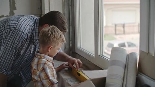 Little Boy Renovating House with Dad