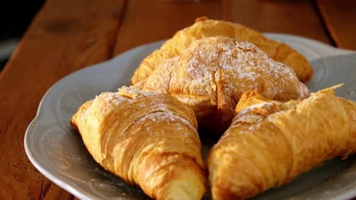 Plate with croissants on table