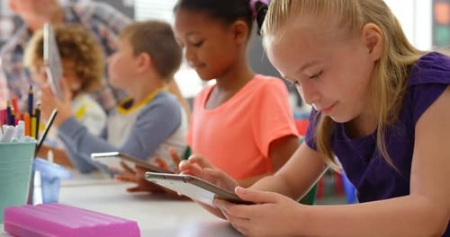 Side view of mixed-race schoolkids studying on digital tablet in the classroom 4k