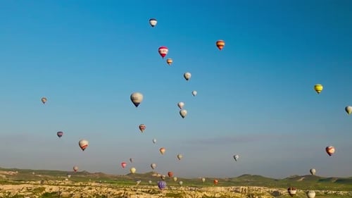 Heißluftballons fliegen über die Berglandschaft von Kappadokien, Türkei.