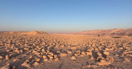 Aerial footage above a rocky desert during sunrise