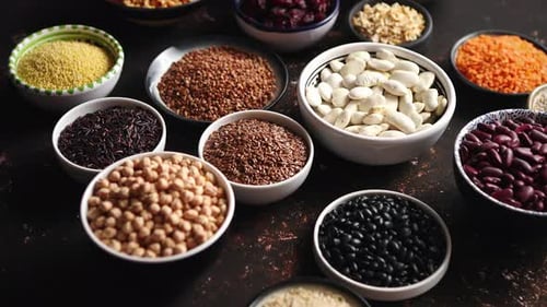 Verschiedene Superfoods in kleinen Schalen auf dunklem, rostigem Hintergrund