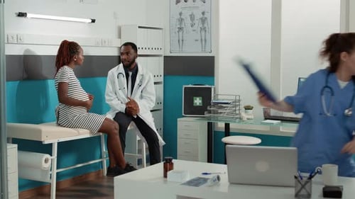 Pregnant Woman Talking with Doctor in Office