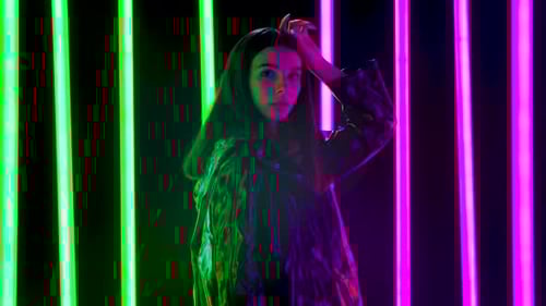 Portrait of a Young Pretty Woman Poses Against a Dark Studio Background with Bright Multicolored