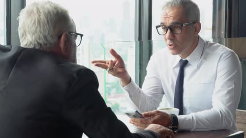 Zwei hochrangige Geschäftsleute diskutieren mit Partnerschaft über die Arbeit im Büro.