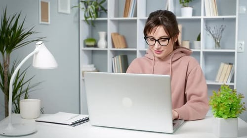 Woman Working on Laptop at Desk Indoors
