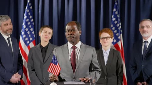Political Speaker Addressing Audience With American Flags