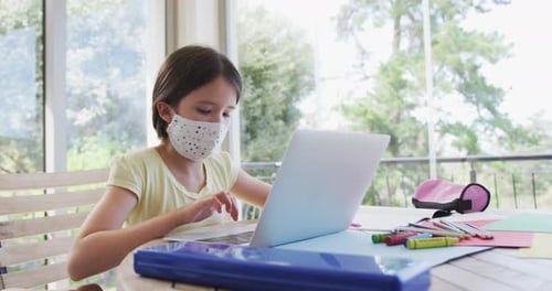 Girl Working on Laptop at Home Wearing Mask
