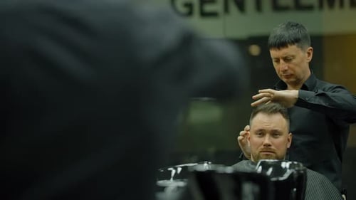 Barber Styling Man's Hair in Modern Barbershop