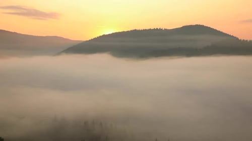 Mountains Rise Above Ethereal Fog During Golden Sunrise